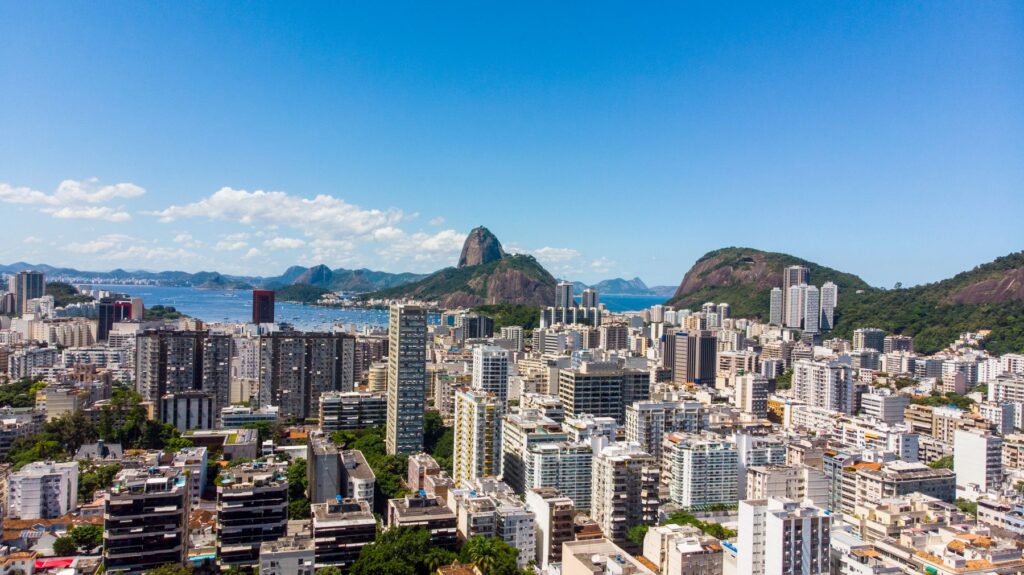Vista aérea de Botafogo, no Rio de Janeiro, com prédios comerciais e residenciais, a enseada e o Pão de Açúcar ao fundo